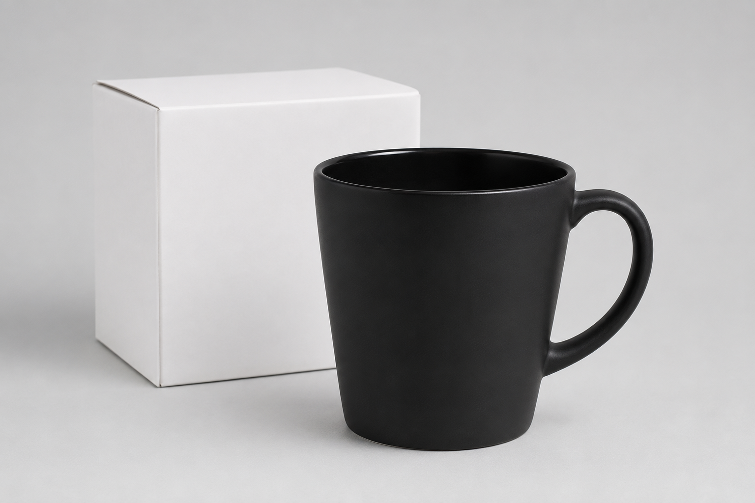 Mazā Latte Magic melnā keramikas krūze ar kasti 300 ml uz gaiši pelēka fotostudijas fona