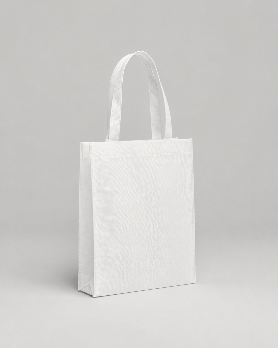 Balta reklāmas sublimācijas soma 26 × 32 cm uz gaiši pelēka studijas fona