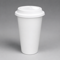 A plain white reusable travel cup with a matching white lid, photographed on a smooth gray studio background.